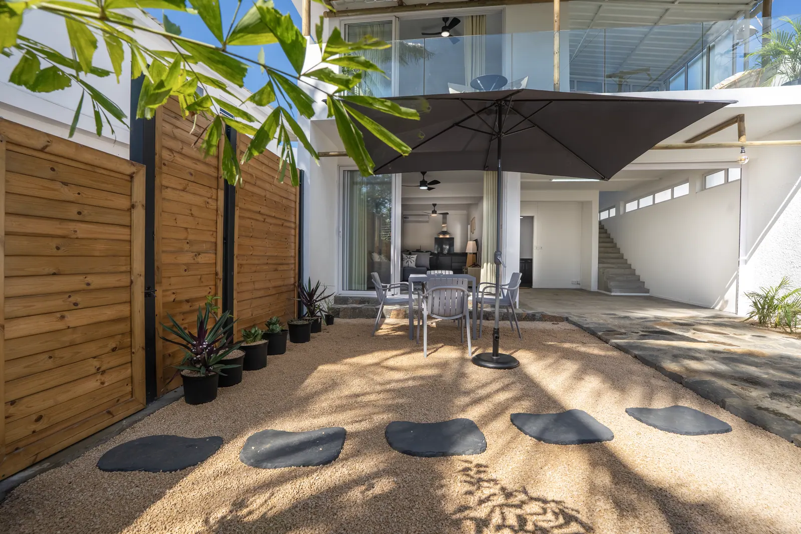 Patio intérieur de la Villa Belladonna avec parasol et palmiers